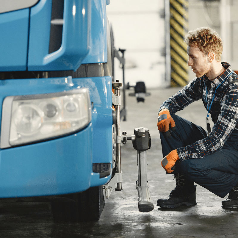 Mechanic inspecting the front of a truck